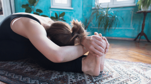 woman doing beginner yoga pose at home featured