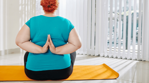 plus sized woman doing yoga pose featured