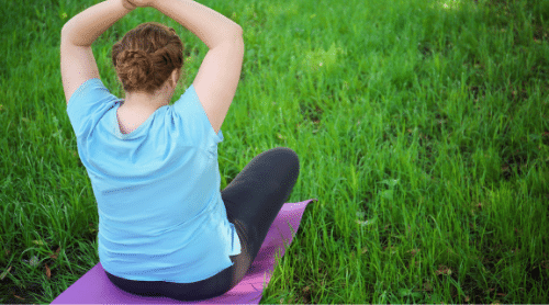 plus size woman doing yoga outside featured