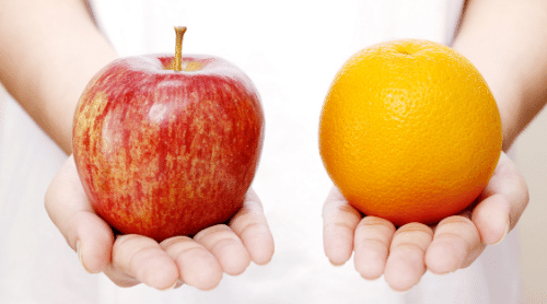 person holding apple and orange featured