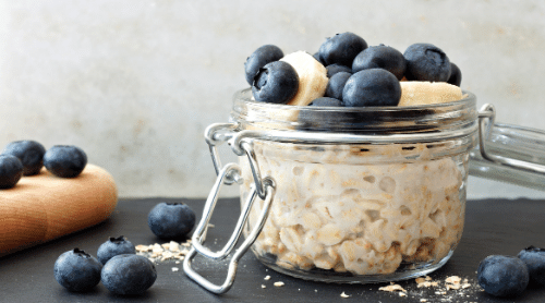 overnight oats in a jar with blueberries and bananas featured