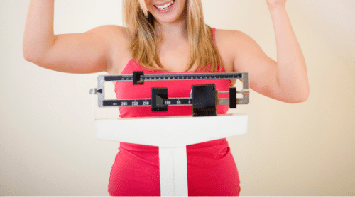 woman celebrating on scale losing 20 lbs featured