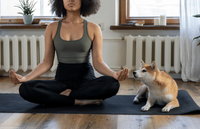 woman meditating at home with her dog